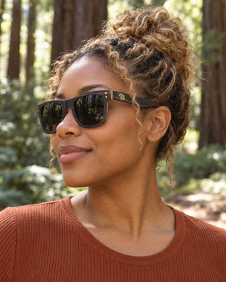Big Basin polarized sunglasses worn by a woman on a trail among giant redwoods in Big Basin