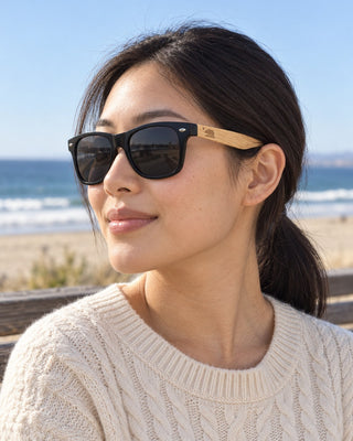 Imperial Beach polarized sunglasses worn by a woman on a beachfront bench in Imperial Beach